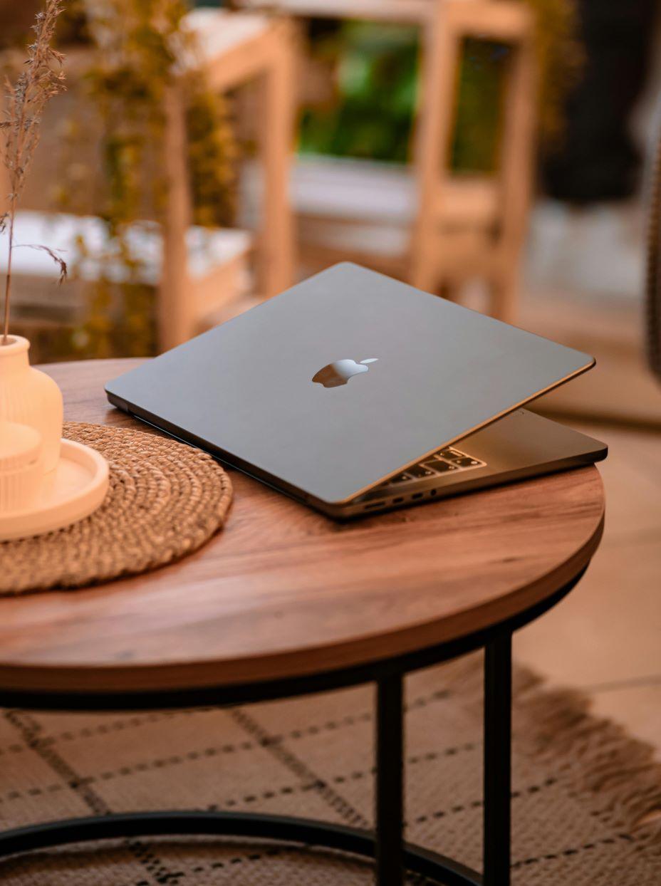 A slightly opened laptop in a warmly-lit office space